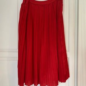 Red pleated knee length silk skirt